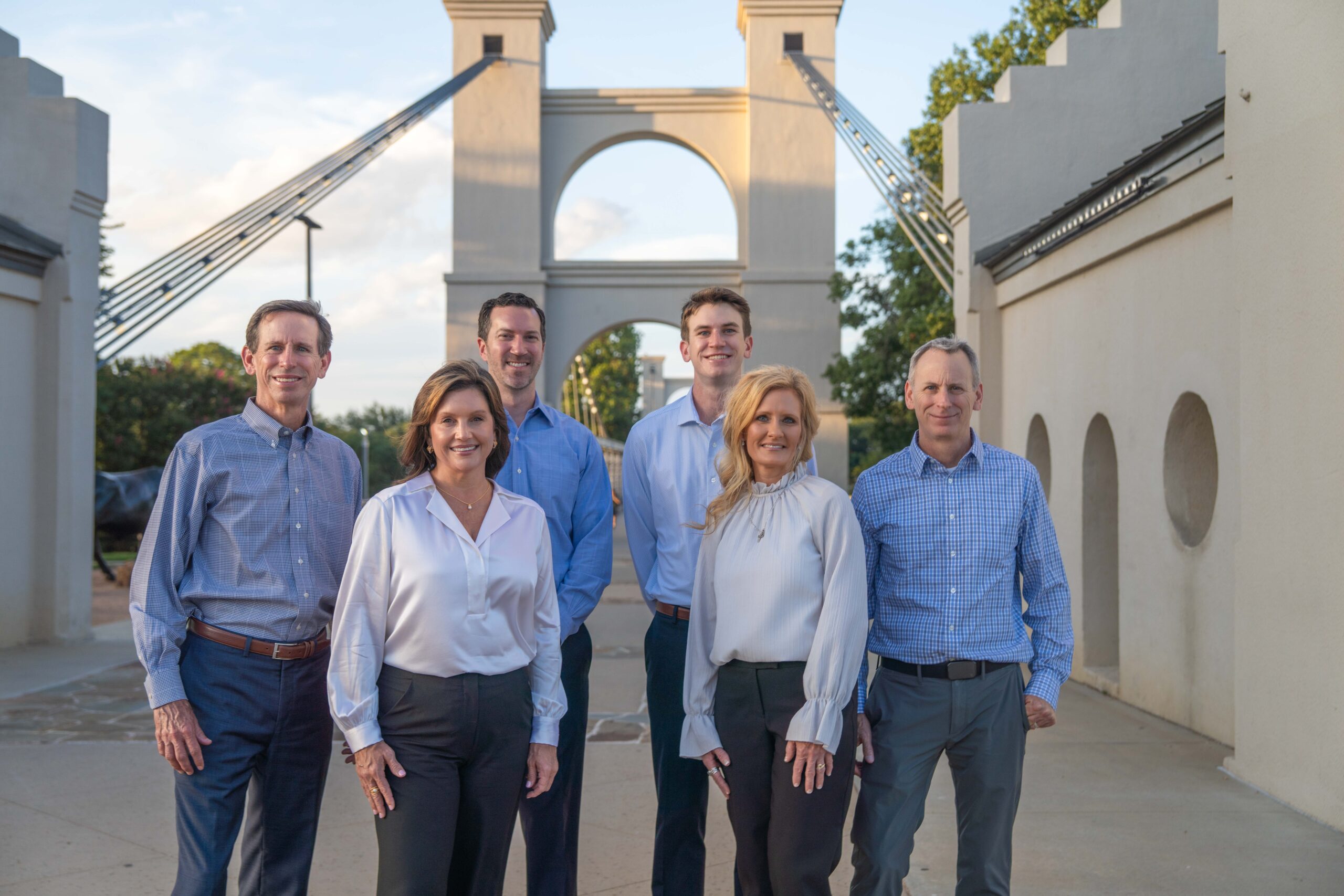 The Lewis Wealth Mangement Team poses on the Waco Suspension Bridge, symbol of their financial advisor team